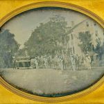 Men in uniform accompany a horse-drawn hearse.